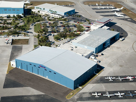 This is a picture of a blue metal airplane hangar with a gray metal roof