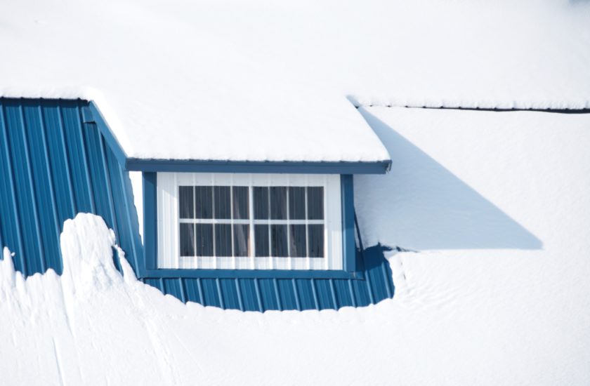 Window in roof of blue barn.