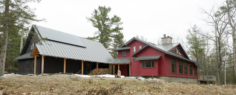 Red modern house with charcoal standing seam metal roofing